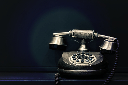 black and brown rotary phone near gray wall